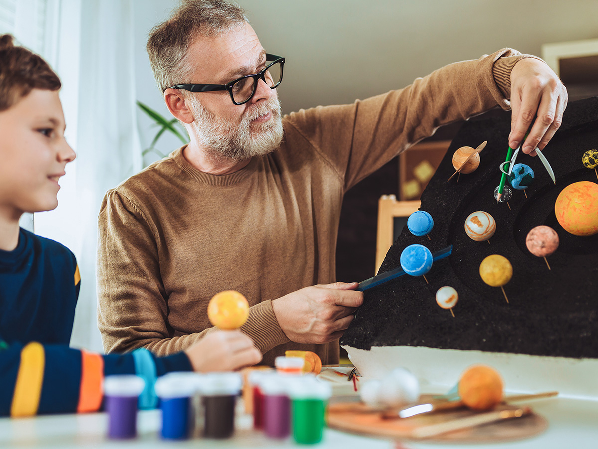 teacher helping young boy with science project