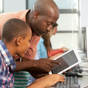 teacher using an ipad to help out a student