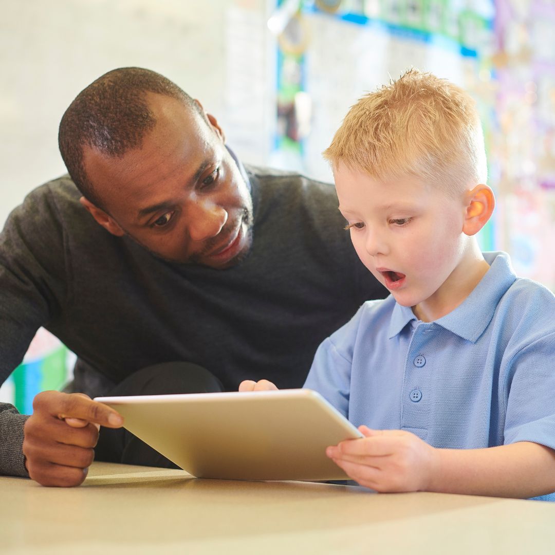 man instructing a boy on how to read