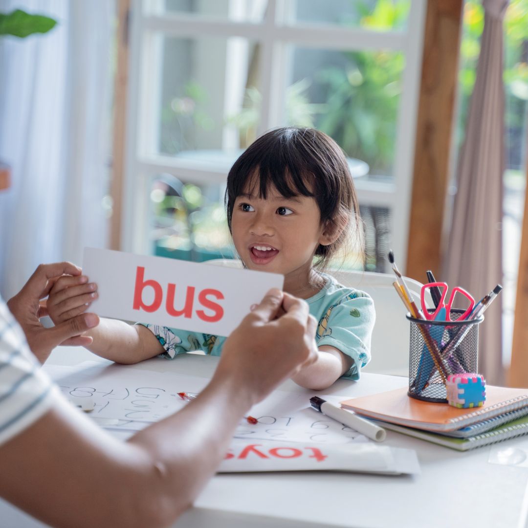 young kid being taught the word "bus"