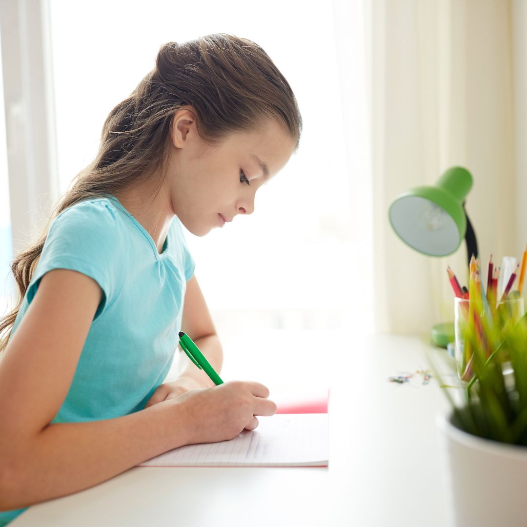 Young Girl Writing in Notebook
