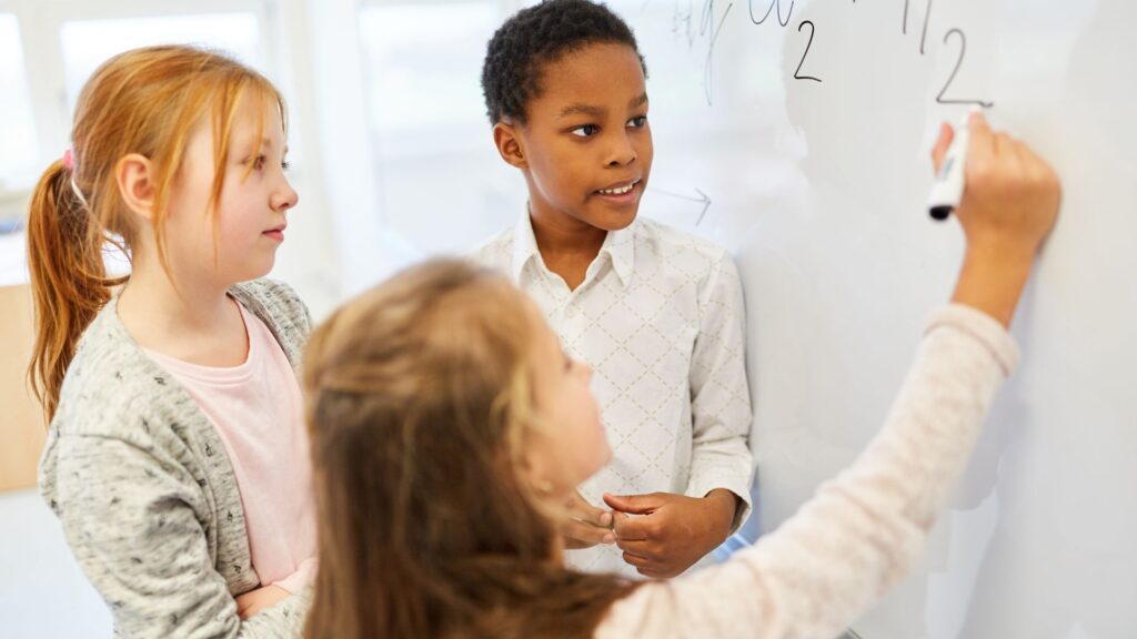 Children doing math on dry erase board